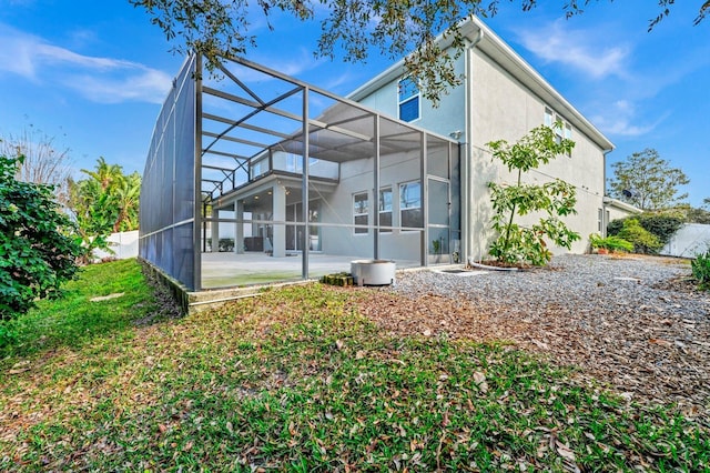 back of property featuring a patio and glass enclosure