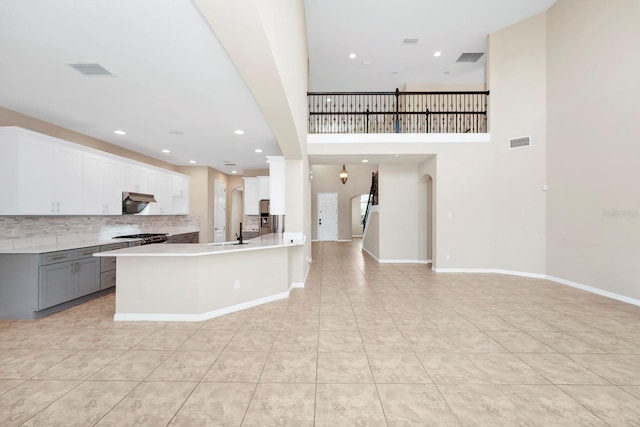 kitchen with gray cabinetry, decorative backsplash, white cabinets, and light tile patterned flooring