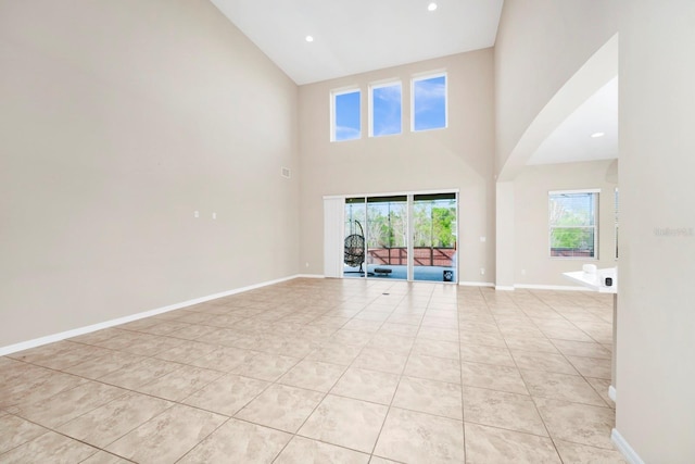 unfurnished living room featuring a high ceiling and light tile patterned floors