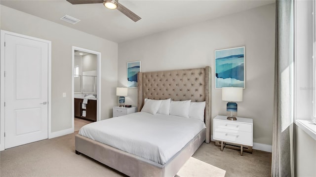 bedroom featuring connected bathroom, ceiling fan, and light colored carpet