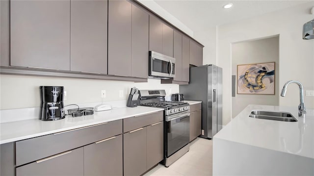 kitchen with gray cabinets, appliances with stainless steel finishes, and sink