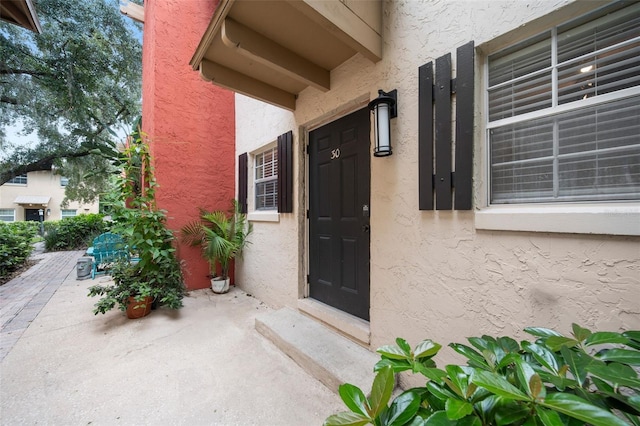 view of exterior entry with a patio