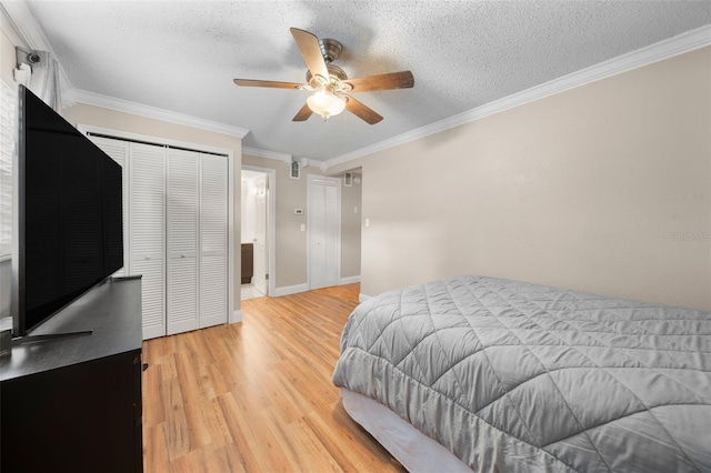 bedroom with ornamental molding, a textured ceiling, ceiling fan, a closet, and light hardwood / wood-style floors