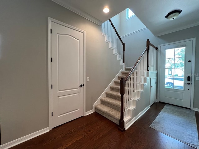 entryway with dark wood-type flooring and ornamental molding