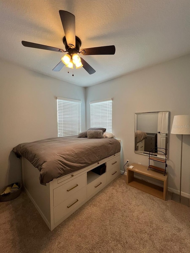 carpeted bedroom featuring a textured ceiling and ceiling fan