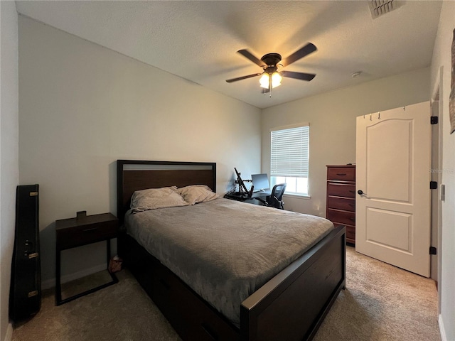 carpeted bedroom featuring a textured ceiling and ceiling fan