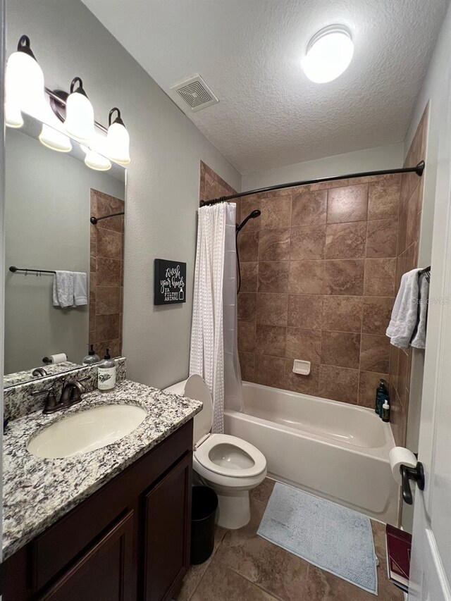 full bathroom with a textured ceiling, vanity, toilet, tile patterned floors, and shower / bath combo