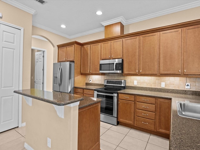 kitchen featuring brown cabinets, stainless steel appliances, and backsplash