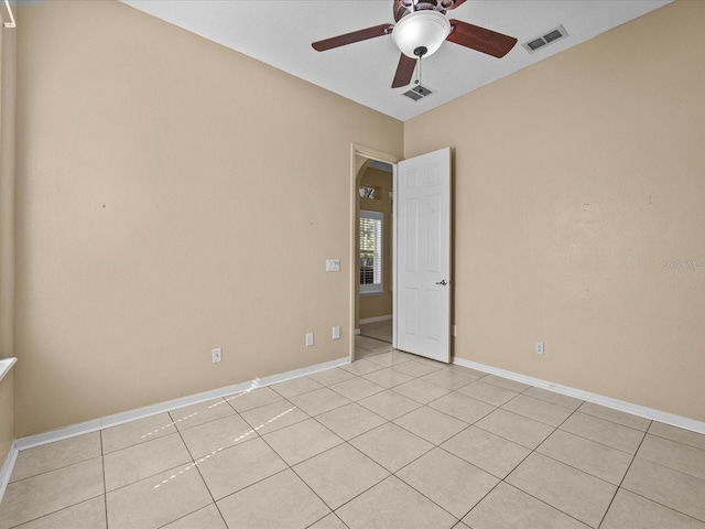 spare room with visible vents, ceiling fan, and baseboards