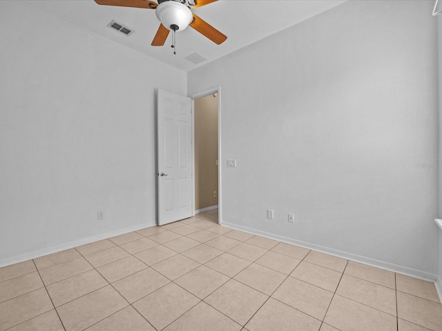 spare room with ceiling fan, visible vents, and baseboards