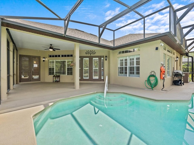 pool with glass enclosure, ceiling fan, french doors, and a patio