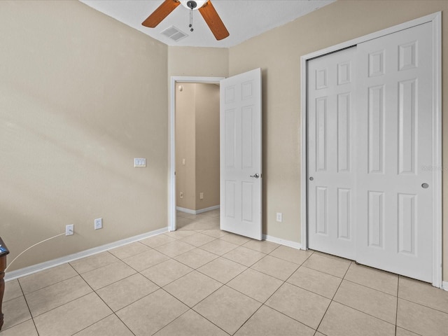 unfurnished bedroom featuring baseboards, visible vents, ceiling fan, a closet, and light tile patterned flooring