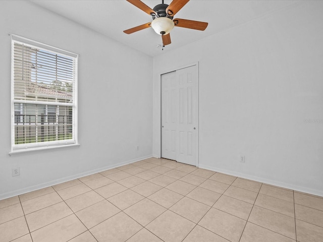 empty room with ceiling fan and baseboards