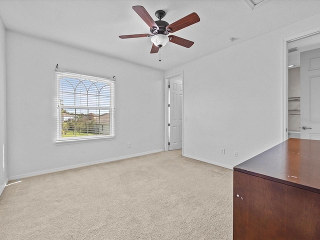 unfurnished bedroom featuring light carpet, ceiling fan, and baseboards