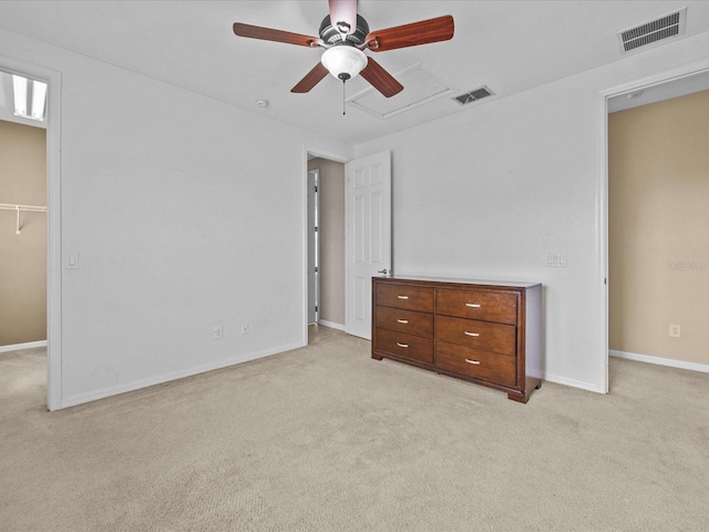 unfurnished bedroom with baseboards, a spacious closet, visible vents, and light colored carpet