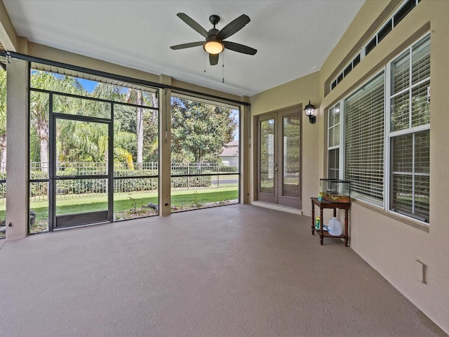 unfurnished sunroom featuring ceiling fan