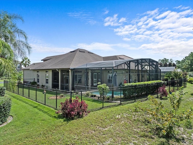 back of house featuring a fenced in pool, glass enclosure, fence, a yard, and stucco siding