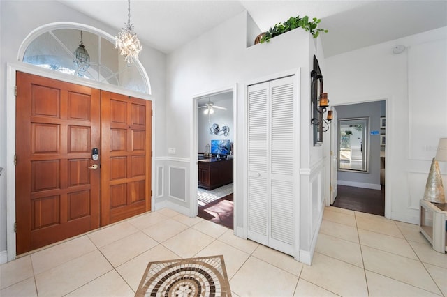 entrance foyer featuring ceiling fan with notable chandelier and light tile patterned floors