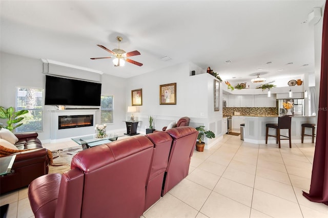 tiled living room with ceiling fan and a healthy amount of sunlight