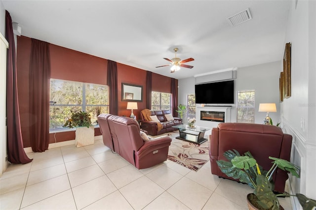 living room featuring light tile patterned floors, ceiling fan, and a healthy amount of sunlight