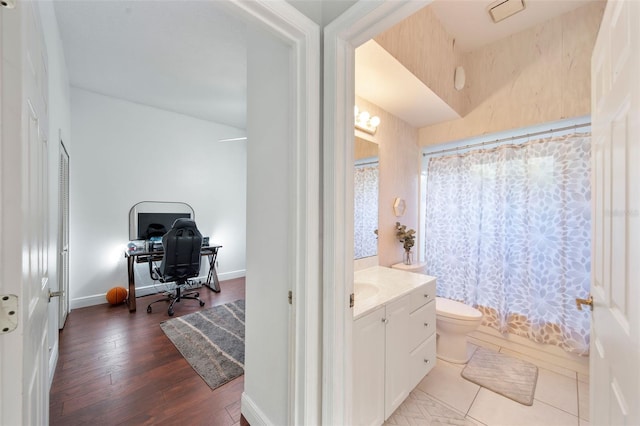 bathroom featuring curtained shower, hardwood / wood-style flooring, vanity, and toilet