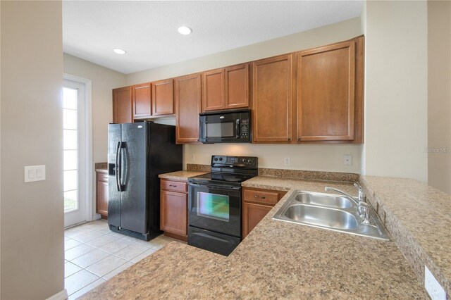 kitchen with black appliances, sink, light tile patterned floors, and plenty of natural light