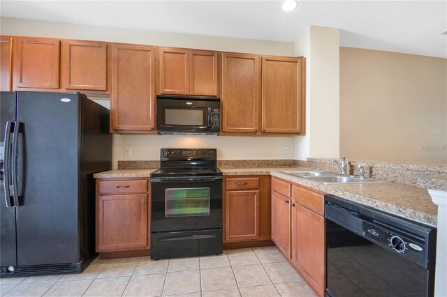 kitchen with black appliances, sink, and light tile patterned floors