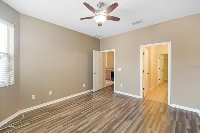 unfurnished bedroom with ceiling fan and dark hardwood / wood-style floors