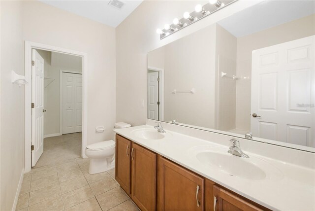 bathroom with tile patterned floors, a shower, vanity, and toilet