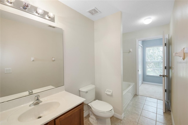 bathroom featuring tile patterned flooring, a textured ceiling, vanity, and toilet