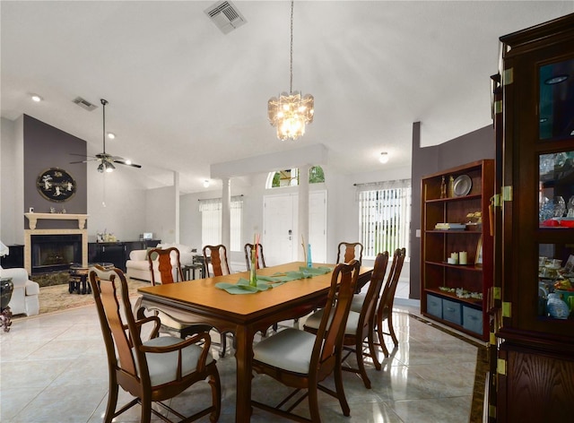 2101 Appy Ln, Apopka, FL 32712 - dining area featuring light tile patterned floors, a tiled fireplace, lofted ceiling, a chandelier, and a ceiling fan