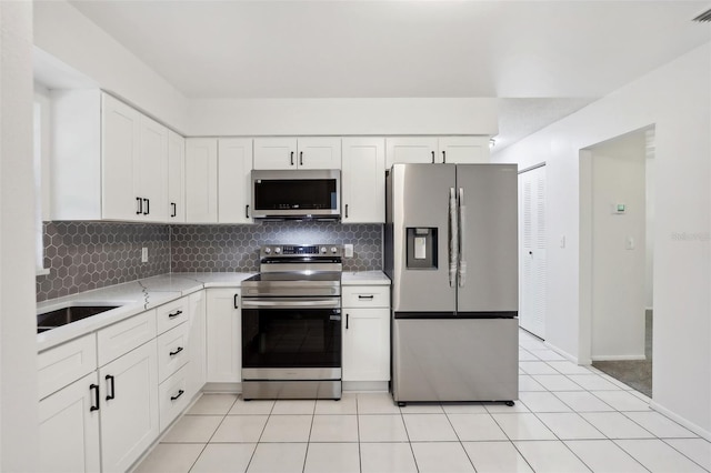 kitchen featuring stainless steel appliances, sink, decorative backsplash, white cabinetry, and light stone counters