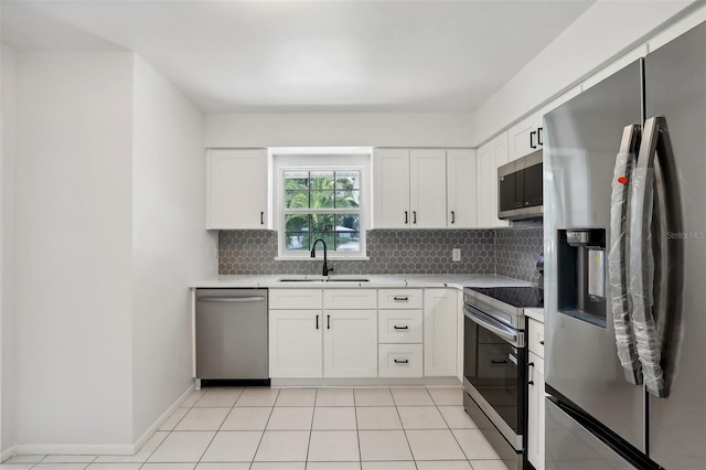 kitchen featuring stainless steel appliances, sink, backsplash, and white cabinets