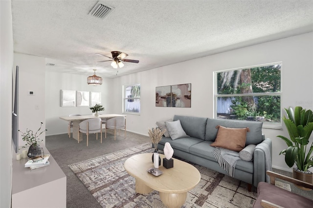 living room with a textured ceiling, ceiling fan, and carpet floors