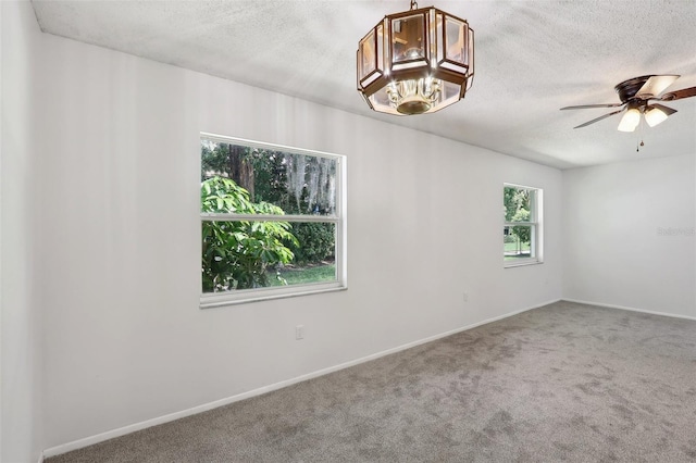 carpeted spare room featuring ceiling fan, plenty of natural light, and a textured ceiling