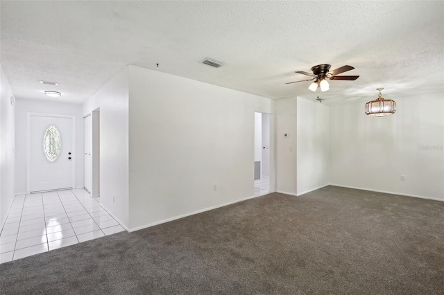 spare room featuring a textured ceiling, light colored carpet, and ceiling fan with notable chandelier