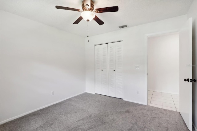 unfurnished bedroom with light colored carpet, ceiling fan, and a closet