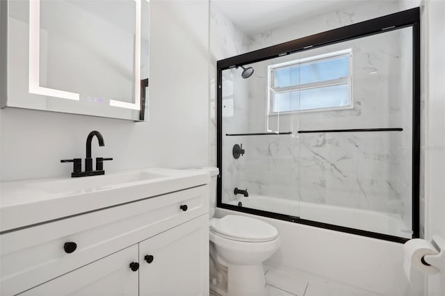 full bathroom featuring vanity, toilet, tile patterned floors, and bath / shower combo with glass door