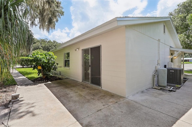 view of side of property featuring central AC unit and a patio