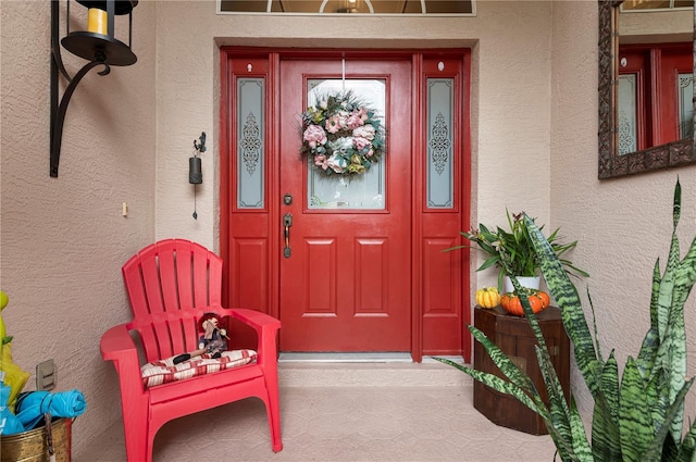 doorway to property featuring stucco siding
