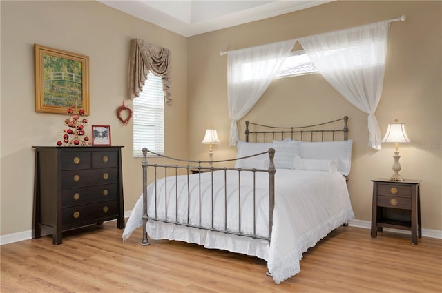 bedroom with wood finished floors and baseboards