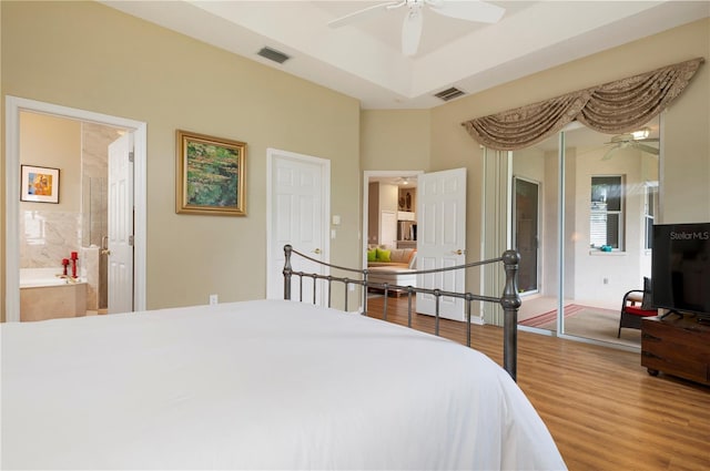 bedroom featuring ensuite bathroom, wood-type flooring, and ceiling fan