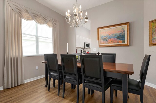 dining room featuring light hardwood / wood-style flooring and a notable chandelier