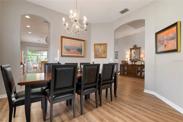 dining room with a notable chandelier and light wood-type flooring