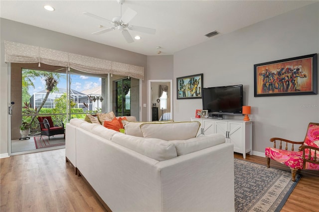 living room with light wood-type flooring and ceiling fan