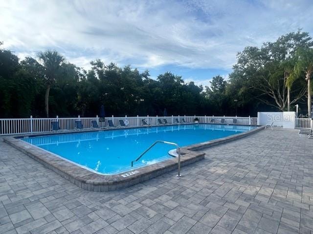 community pool featuring fence and a patio
