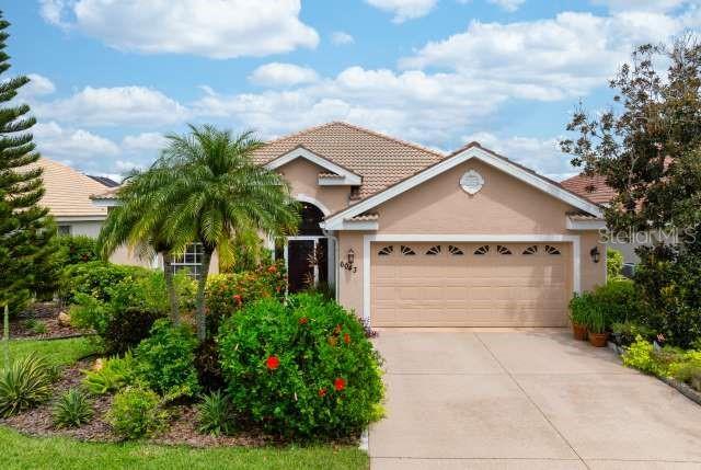 view of front of home with stucco siding, concrete driveway, a garage, and a tiled roof