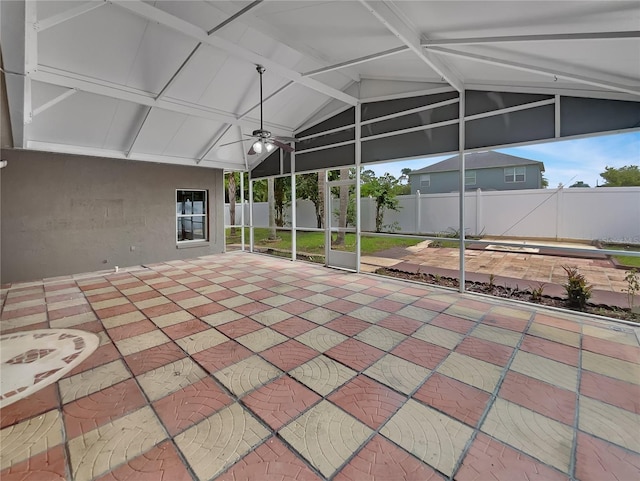 unfurnished sunroom featuring vaulted ceiling with beams and a ceiling fan