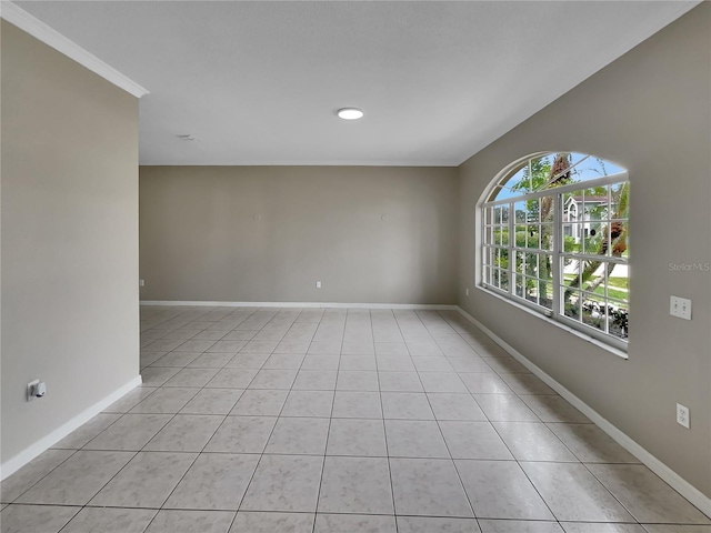 empty room with crown molding and light tile patterned floors