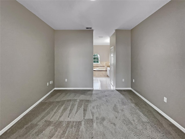 carpeted empty room featuring visible vents and baseboards